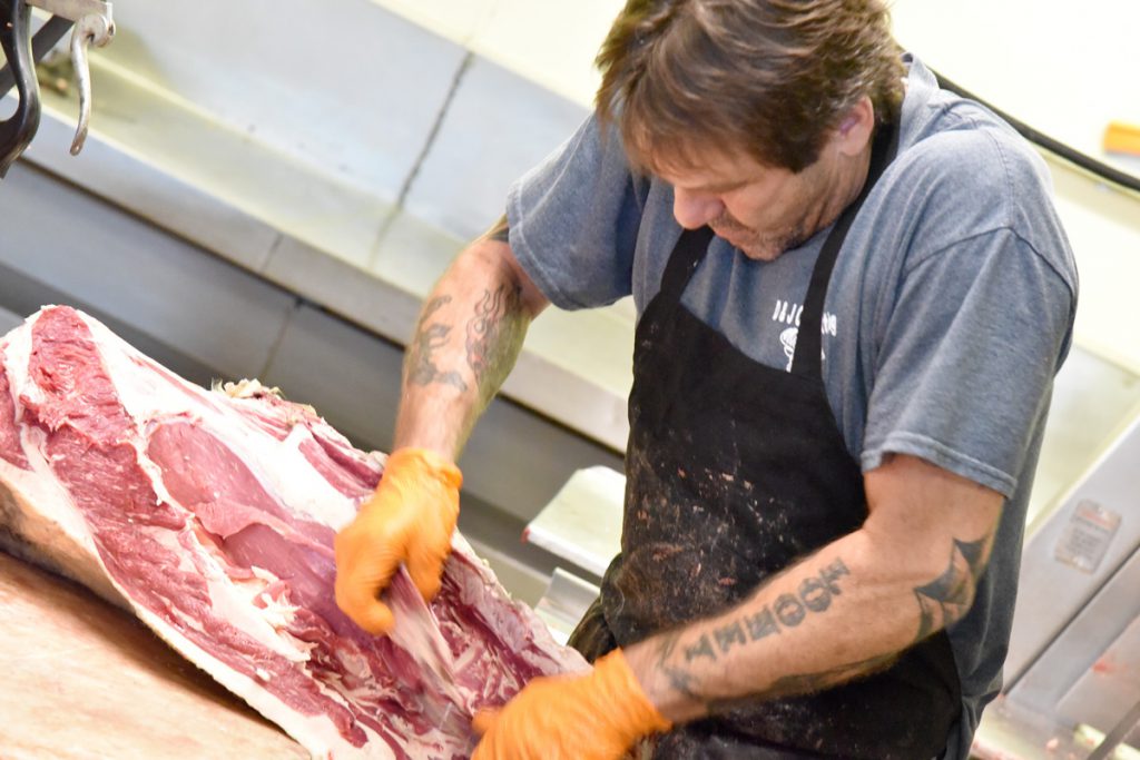 Butcher breaking down a cut of beef